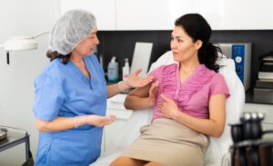 A plastic surgeon discusses breast augmentation and breast lift options with a woman during a cosmetic surgery consultation at the clinic